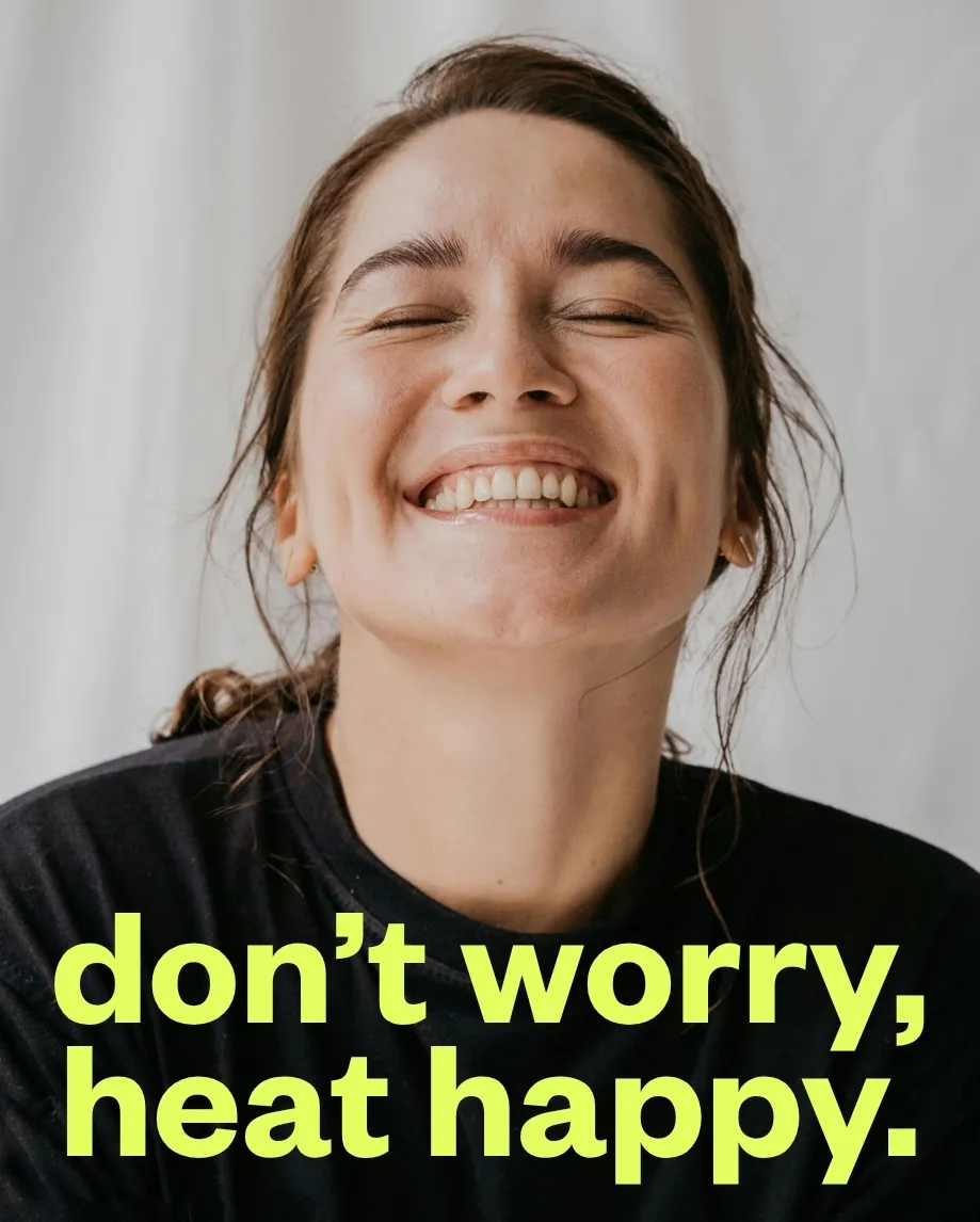 Lachende Frau mit geschlossenen Augen, darunter in Neongelb der Schriftzug "don't worry, heat happy."